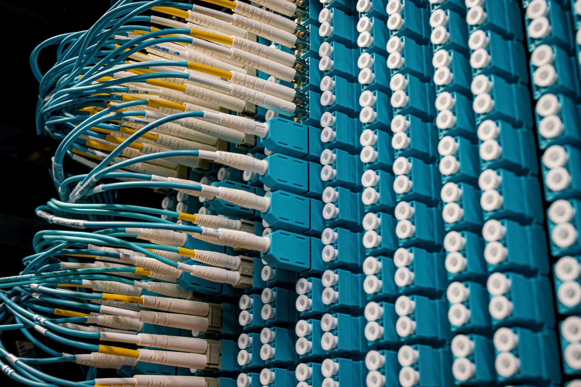 Teal fiber optic connectors on a patch panel